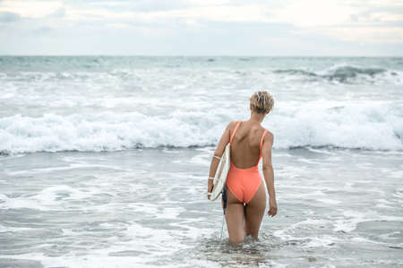 Woman with surfboard on beachの写真素材