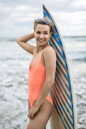 Girl with surfboard on beachの写真素材
