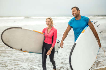 Couple of surfers on oceans shore