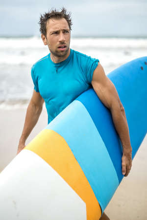 Man with surfboard on beachの写真素材