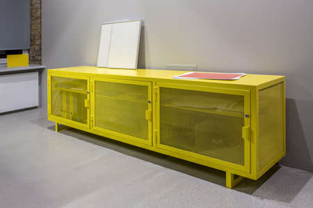 Reticulated metal yellow lockers on the background of the gray wall in the interior in a loft style. Closeup. Horizontal.の写真素材