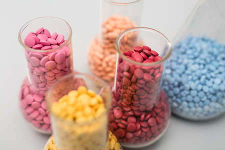Multicolored pills in glass flasks