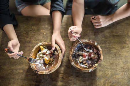 Hands with forks and bowls with foodの写真素材