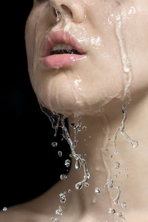 Water splashes on womans faceの写真素材