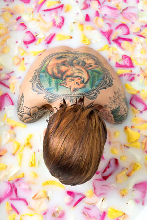 Tattooed girl relaxing in bathの写真素材