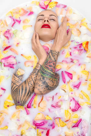 Tattooed girl posing in bath