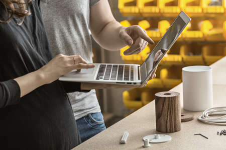 Man and woman using laptop in workshopの写真素材