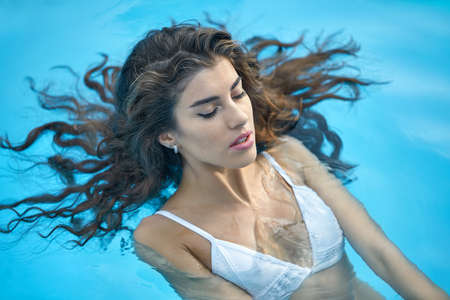 Model in swimming pool outdoorsの写真素材