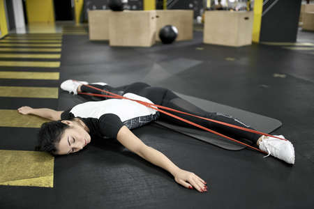 Sportive girl does exercise in gymの写真素材