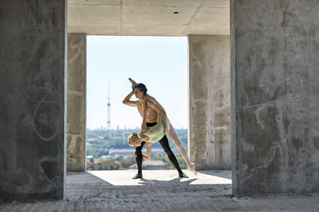 Ballet dancers posing at unfinished buildingの写真素材