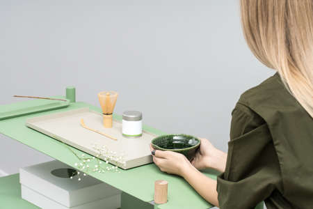 Girl with bowl sits at tableの写真素材