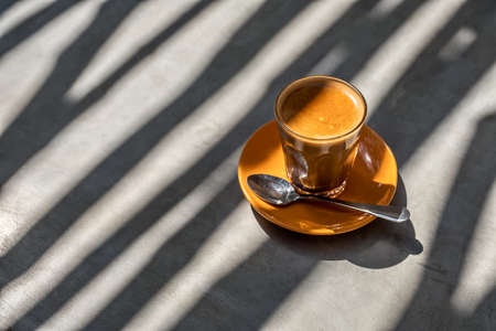 Latte drink in glass on saucerの写真素材