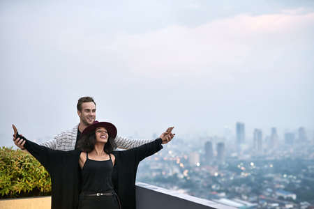 Lovely interracial couple on balconyの写真素材
