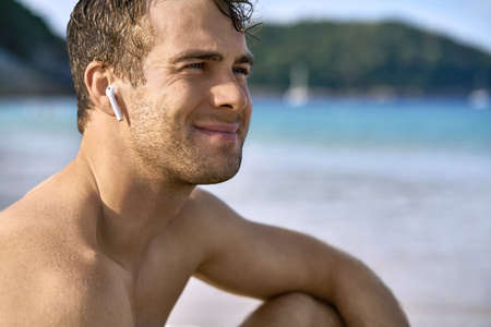 Tanned guy on beach. Daylight morning shooting.の写真素材