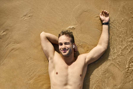 Tanned guy on beach. Daylight morning shooting.の写真素材