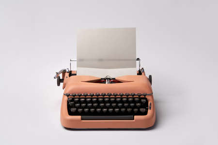 Retro typewriter coral color in studio. Studio shot.の写真素材