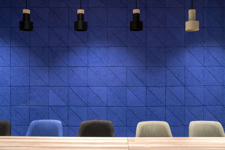 Meeting room in a luminous office with a textured blue wall. There are wide wooden tables with multicolor chairs, hanging dark and light lamps. Horizontal.の写真素材
