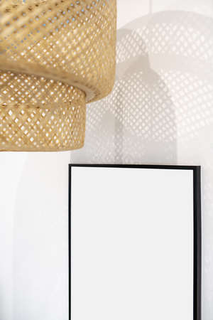 Closeup photo of hanging wicker beige lamp on light backgroundの写真素材