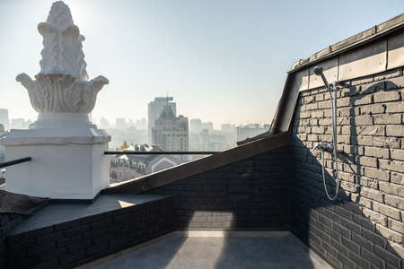 Cozy small terrace with brick walls on sunny cityscape backgroundの写真素材