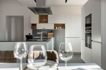 Sunny modern kitchen with white walls and tiled floorの写真素材