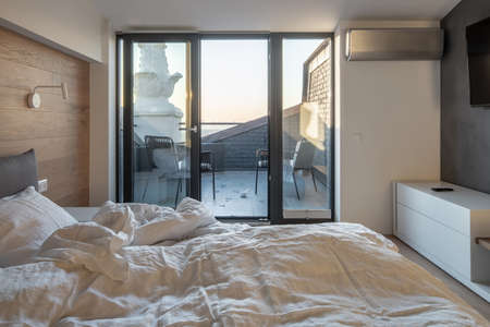 Sunny bedroom in modern style with light wallsの写真素材