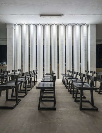 Rows of black wooden chairs on the background of the white columnsの写真素材