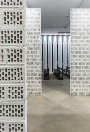 White brick partitions on the background of the hall with a lot of dark wooden chairsの写真素材
