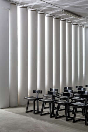 Dark wooden chairs on the background of the white columnsの写真素材