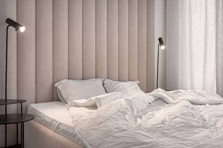 Stylish bedroom in modern style with brown textile wall panelの写真素材