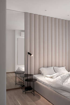 Stylish bedroom in modern style with brown textile wall panelの写真素材