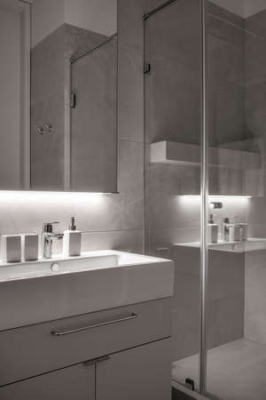Stylish bathroom in modern style with tiled walls and illuminationの写真素材