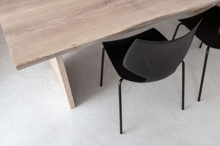 Two black chairs by the light wooden tableの写真素材