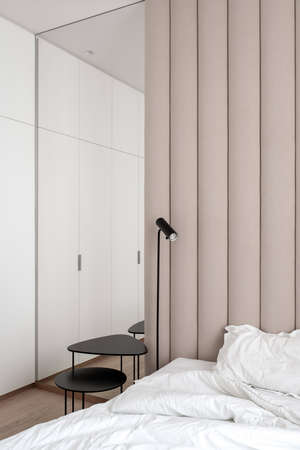 Stylish bedroom in modern style with brown textile wall panelの写真素材