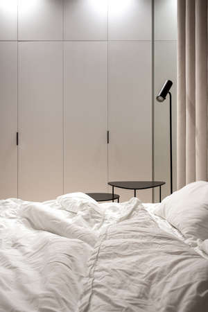 Stylish bedroom in modern style with brown textile wall panelの写真素材