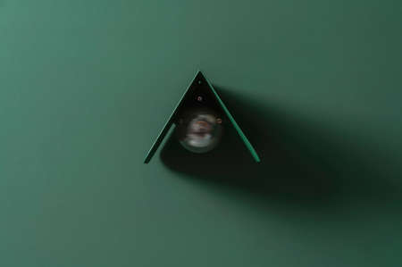 Fancy dark green metal lamp on colorful wall in studioの写真素材