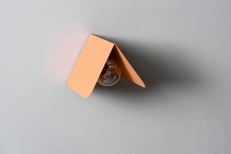 Fancy coral metal lamp on gray wall in studioの写真素材