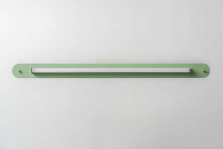 Green metal lamp on gray wall background in studioの写真素材