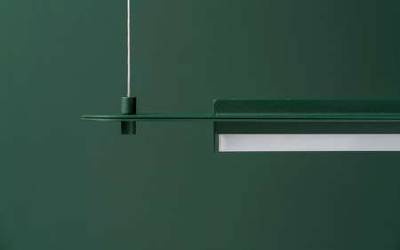 Dark green metal lamp hanging on colorful wall background in studioの写真素材