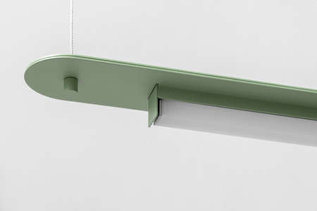 Green metal lamp hanging on gray wall background in studioの写真素材