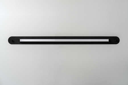 Black metal lamp on gray wall background in studioの写真素材