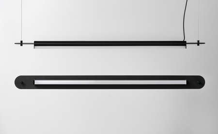 Black metal lamps hanging on gray wall background in studioの写真素材
