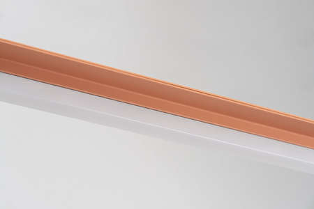 Orange metal lamp on gray wall background in studioの写真素材