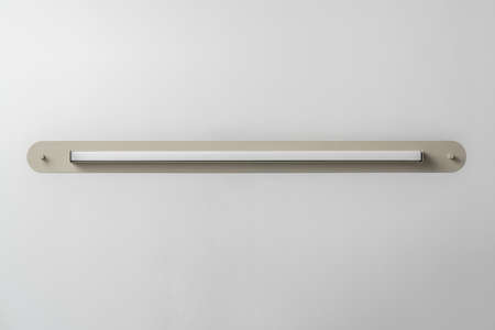 Beige metal lamp on gray wall background in studioの写真素材