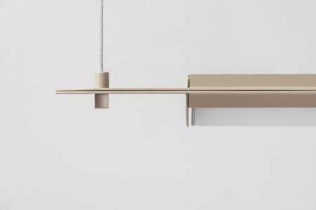 Beige metal lamp hanging on gray wall background in studioの写真素材