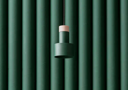 Dark green metal-wooden lamp hanging on folded colorful wall background in studioの写真素材