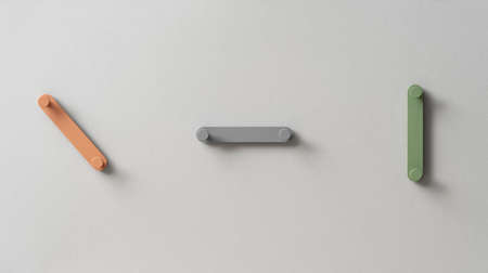 Fancy multicolored metal hangers on gray wall in studioの写真素材