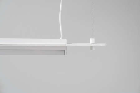 White metal lamp hanging on gray wall background in studioの写真素材