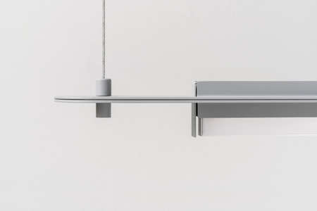 Gray metal lamp hanging on light wall background in studioの写真素材