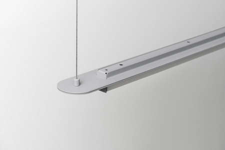 Gray metal lamp hanging on light wall background in studioの写真素材