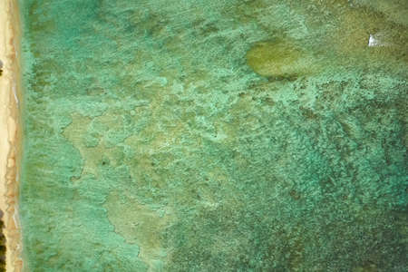 Top view at tropical coastline with sand beach and colorful sea